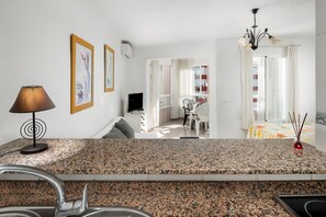 A kitchen with granite countertops, a sink, a lamp, and a dining area with a table and chairs. - Apartment 'Estudio 03 -09' with Sea View, Wi-Fi and Air Conditioning (Torrox)