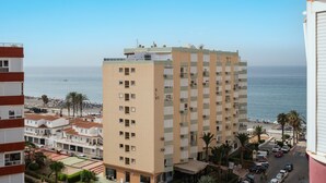 A high-rise building with multiple balconies, a view of the beach, and parked cars. - Studio Apartment 'Estudio 08 - 09' with Sea View, Wi-Fi and Air Conditioning (Torrox)