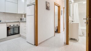 Una cocina moderna con armarios blancos, un microondas y un horno.