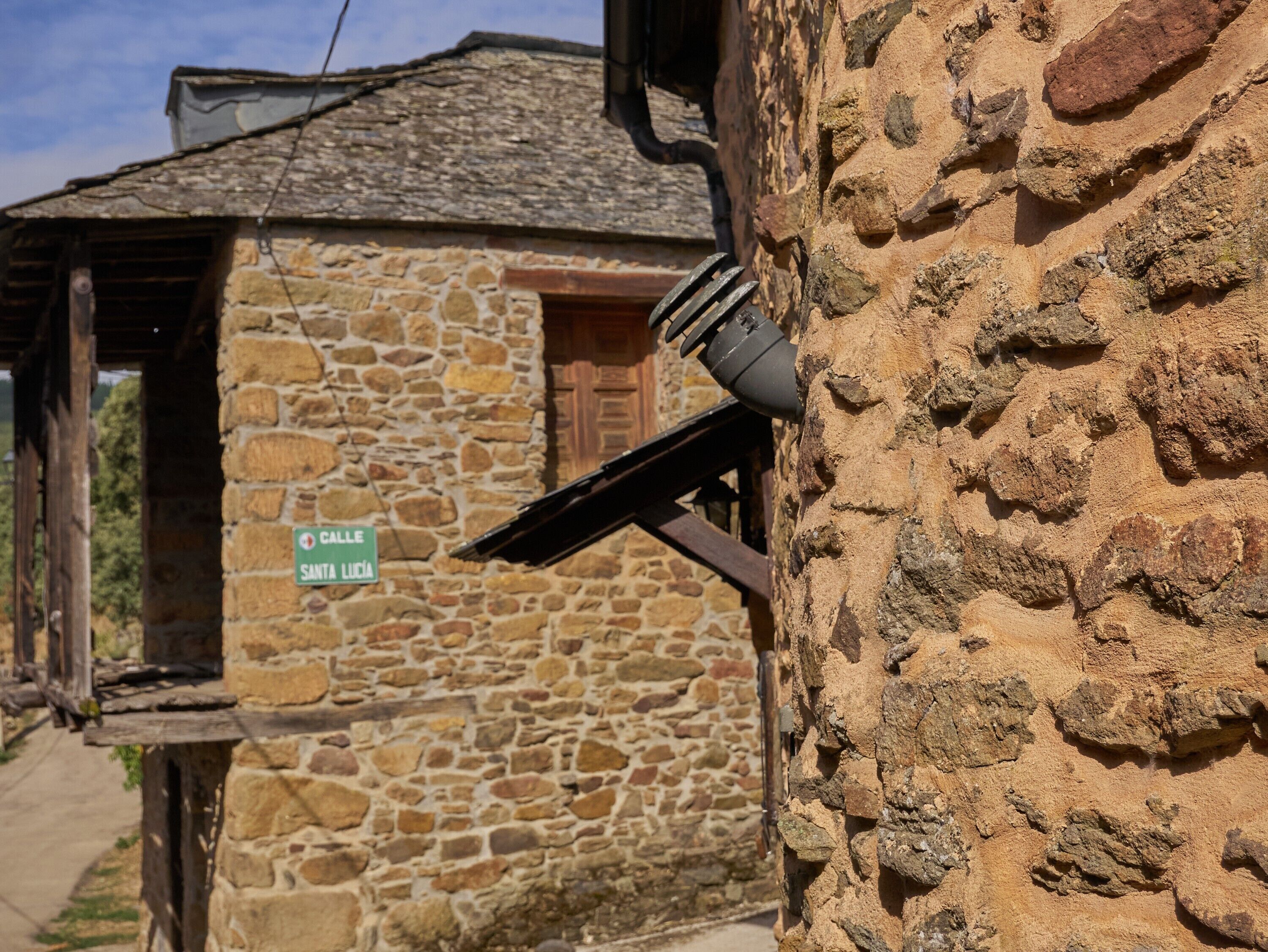 A stone building with a sign reading 'Calle Santa Lucia.'
