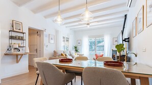A modern living room with a glass dining table, comfortable seating, a coffee station, and a large window. - Villa 'Tranquila El Retiro' with Private Pool, Wi-Fi and Air Conditioning (Málaga)