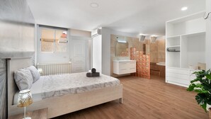 A modern bedroom with a wooden bed, a bedside lamp, a bathroom with a shower, and a large mirror. - Vacation Apartment 'Beach Holidays' with Shared Pool, Wi-Fi and Air Conditioning (Adeje)