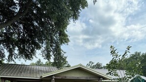 A single-story house with a porch, a covered patio, and a small garden area.