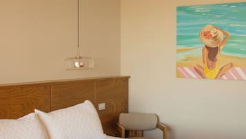 Un dormitorio con cama, cabecera de madera, lámpara colgante, una silla pequeña y aire acondicionado instalado en la pared.