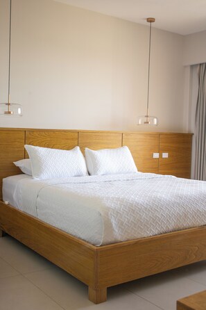 A wooden bed with white bedding and two pendant lights. - Costa Elegante Hotel & Suites (Puerto Peñasco)