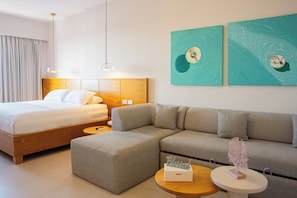A modern hotel room with a bed, sofa, and two paintings on the wall. - Costa Elegante Hotel & Suites (Puerto Peñasco)