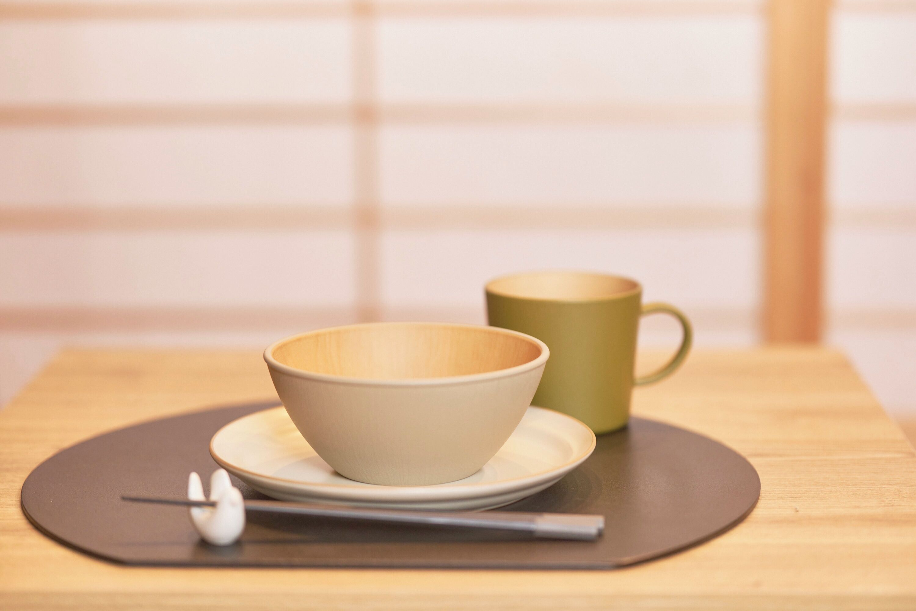 Une table avec un bol et une tasse posés sur un set de table.
