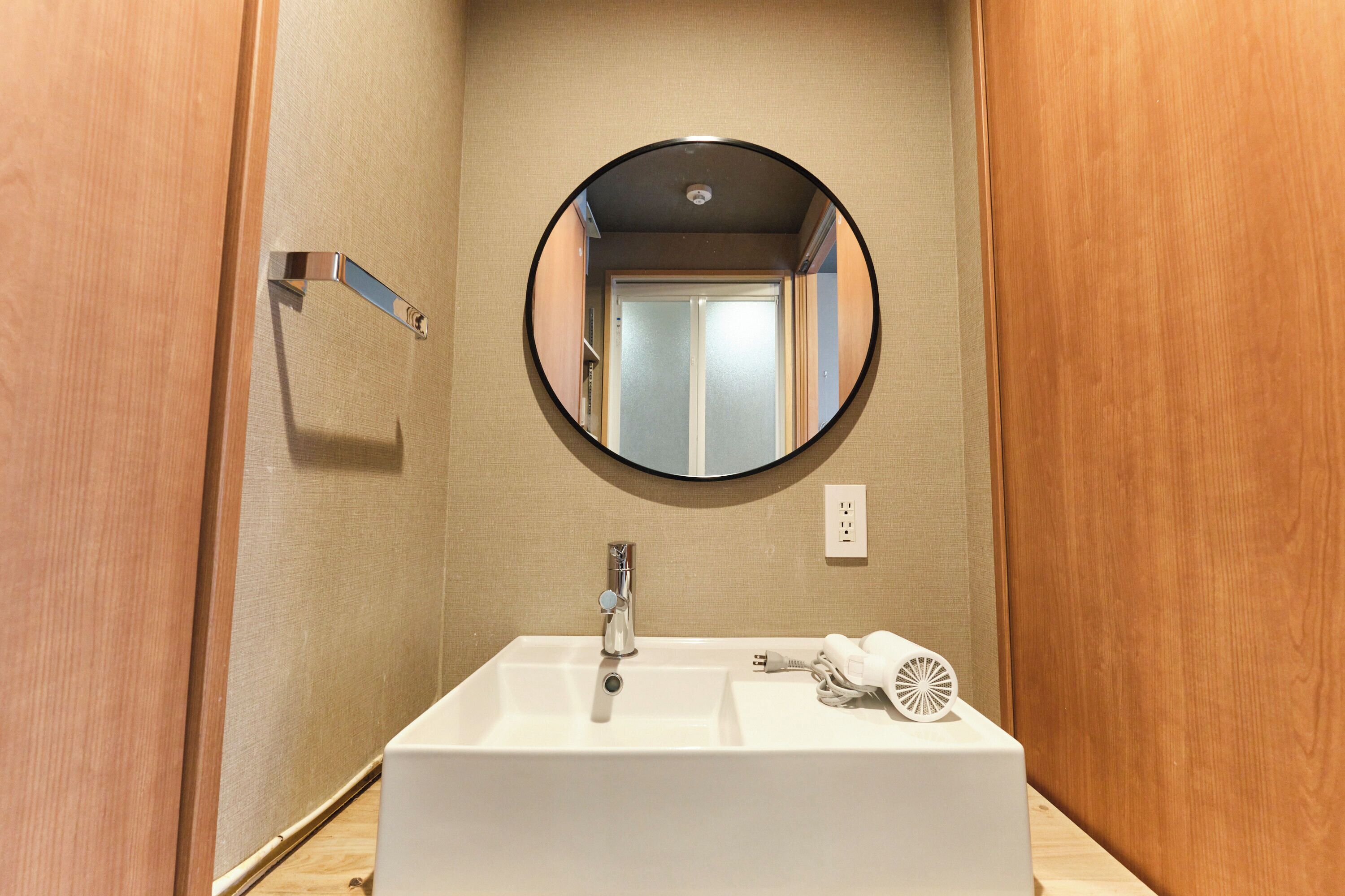A bathroom with a white sink, a mirror, and a towel rack.