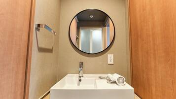A bathroom with a white sink, a mirror, and a towel rack.