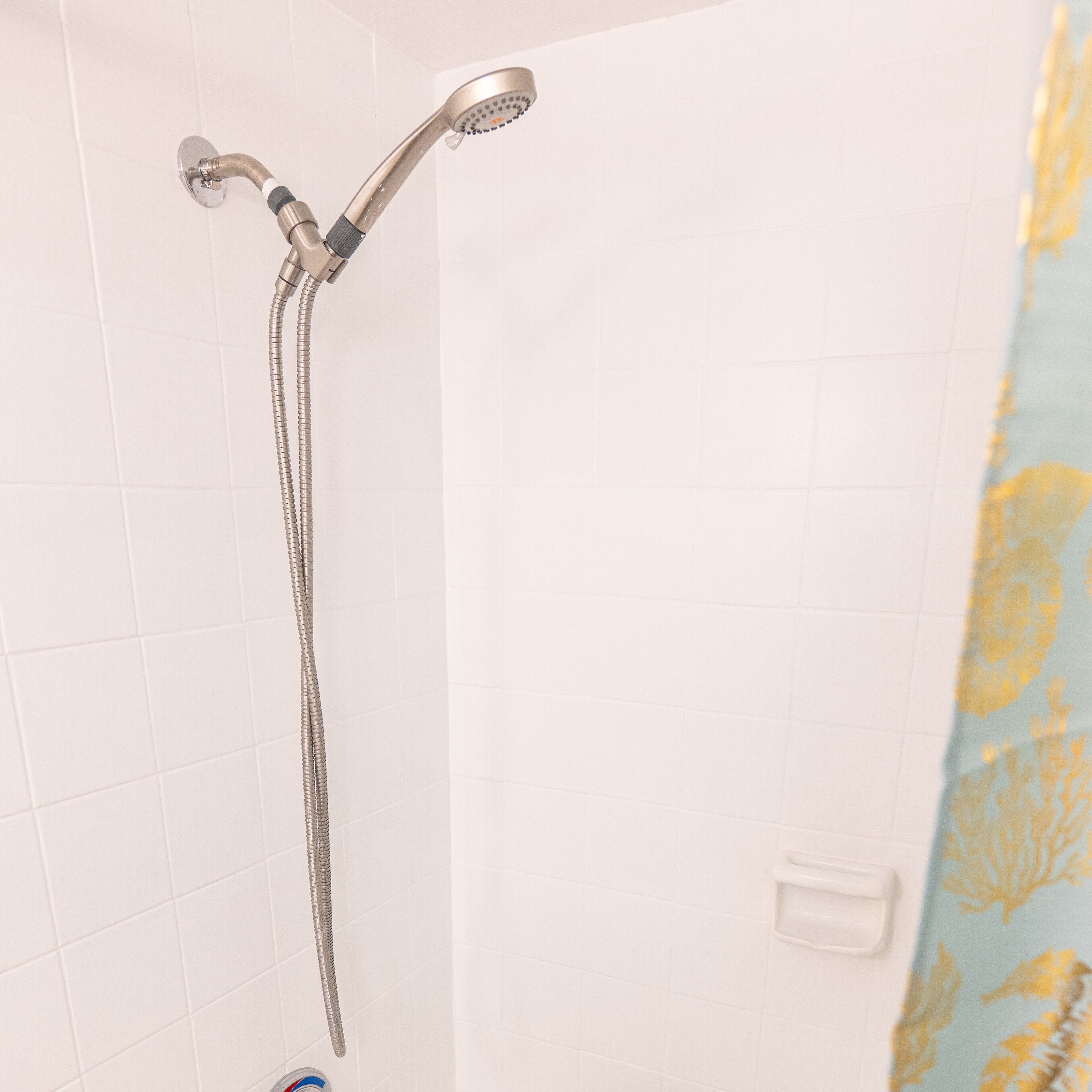 A shower with a handheld showerhead and a flexible hose.