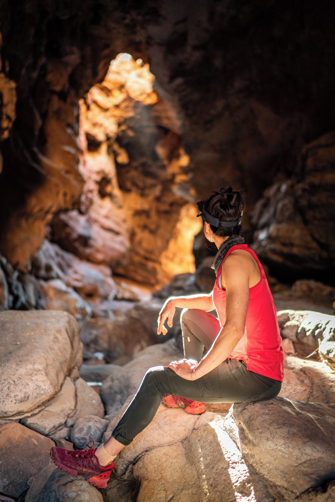 Une personne assise sur des rochers dans une grotte.