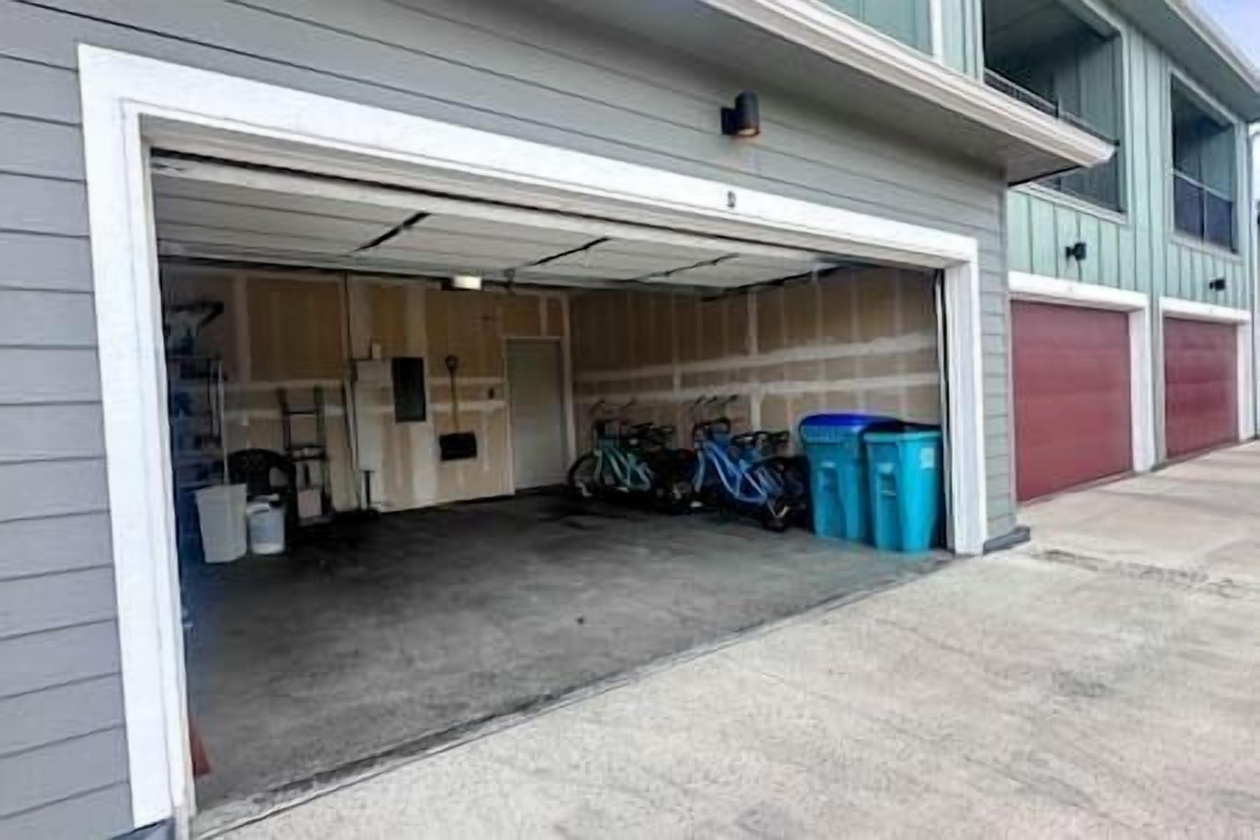 Un garage avec des vélos et des poubelles.