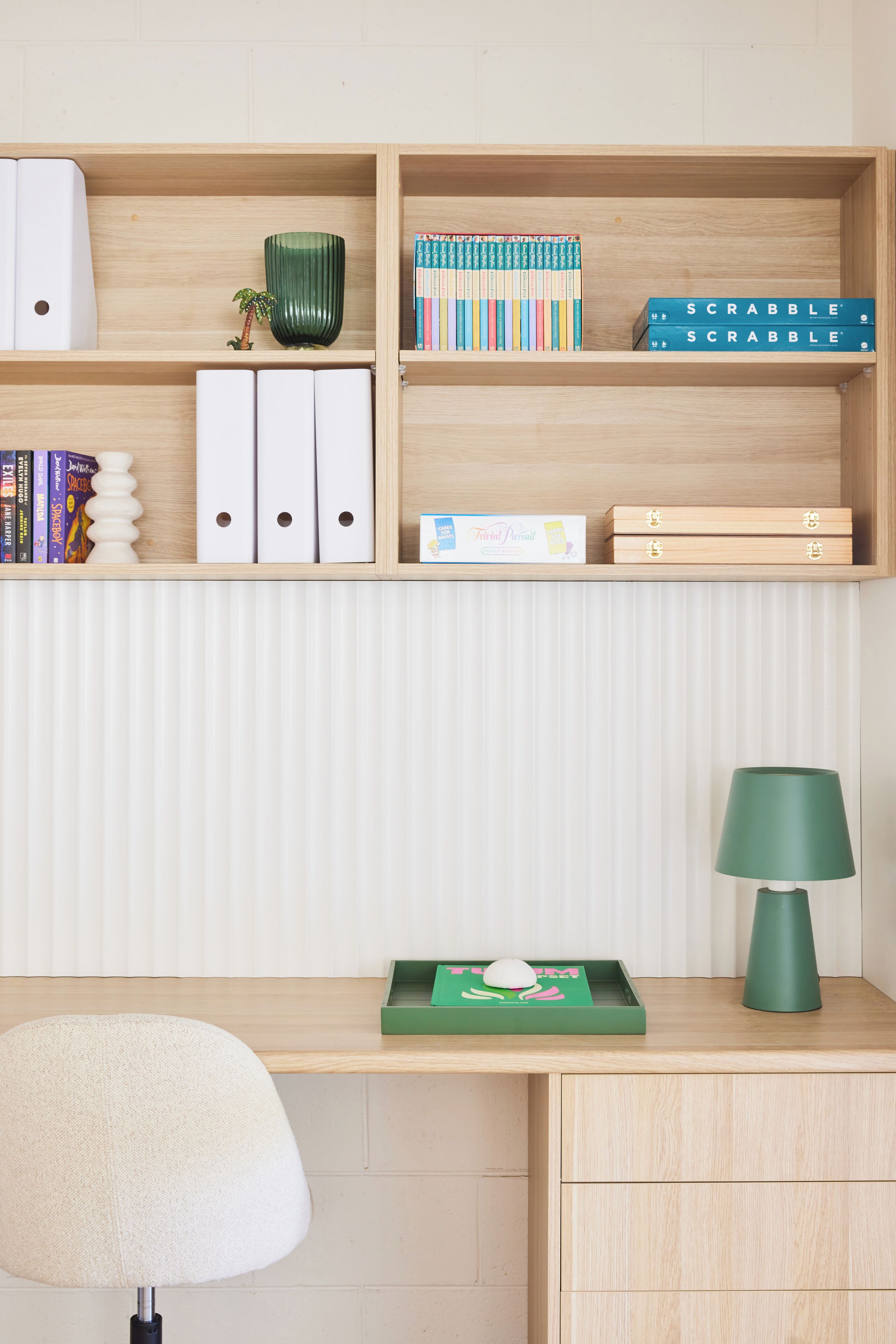 Ein ordentlich eingerichteter Arbeitsplatz mit Schreibtisch, Regalen und einer Lampe.
