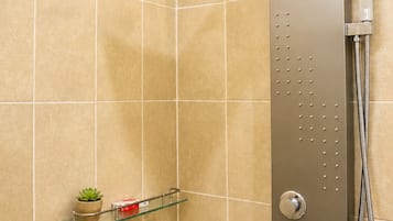A modern shower with a handheld showerhead and a wall-mounted control panel.