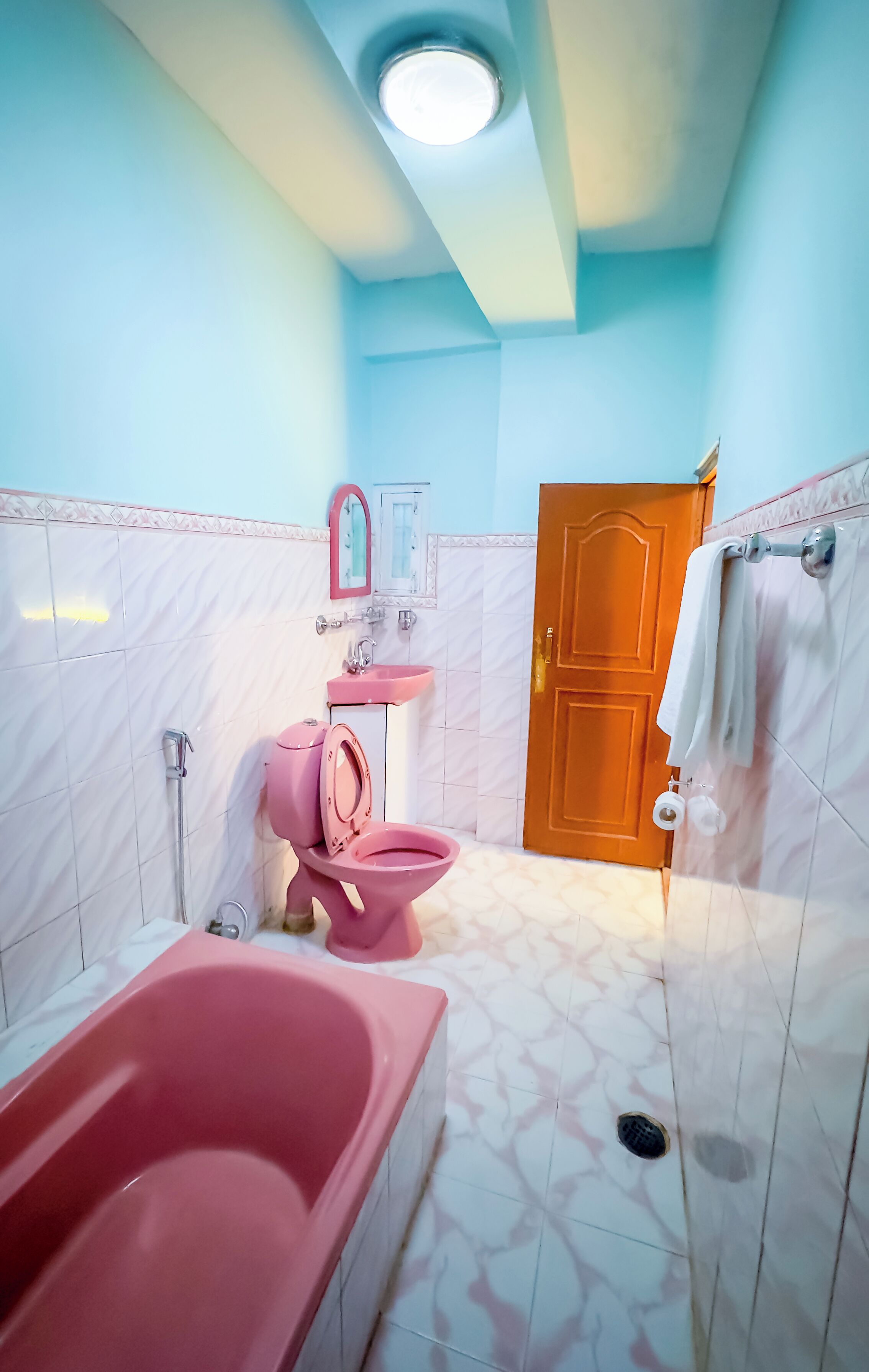 A bathroom with a pink bathtub, a pink toilet, and a sink.