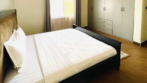 Una cama bien hecha con sábanas blancas en una habitación de hotel.