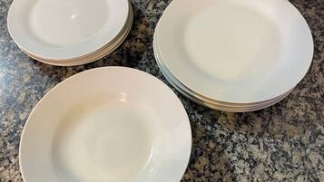 Drie witte borden gestapeld op een granieten aanrecht.