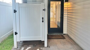 A white door with a black handle, a glass door, and a welcome mat.