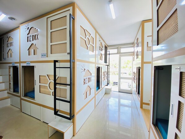 A hotel corridor with multiple rooms, each with a unique number and a small window. - Bossa Nova (Da Nang)