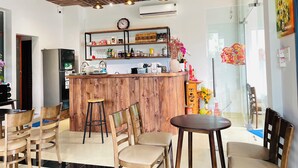 Una cocina moderna con detalles de madera, una isla central con utensilios de bar y una zona de comedor con sillas y una mesa.