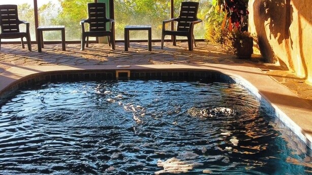 Un espace piscine avec des chaises et un panneau indiquant qu'il est interdit de fumer.