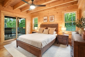 A wooden cabin bedroom with a bed, nightstands, and a dresser.