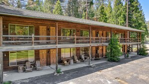 A two-story log cabin with multiple rooms, outdoor seating, and a view of the surrounding forest. - Suite Meadow Camp Nelson Lodge# 7 (Springville)
