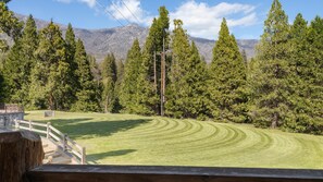 A grassy field with a wooden fence and a wooden structure in the foreground. - Suite Meadow Camp Nelson Lodge# 7 (Springville)