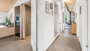 A modern interior with a high ceiling, a visible staircase, and a fireplace in the background. - "Noreen" - 1.4km to the fjord by Interhome (Hemmet)