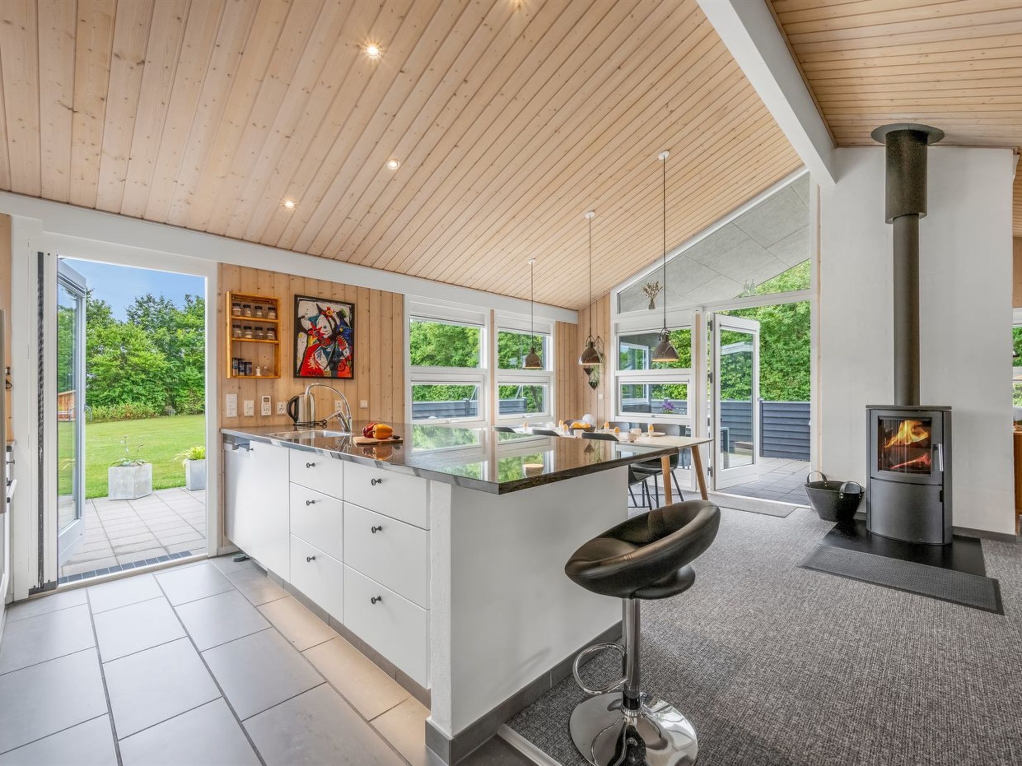 A modern kitchen with a large island, a built-in stove, and a view of the outdoors.