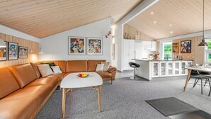 A modern living space with a brown leather sofa, a white coffee table, and a kitchen area with white cabinets and a dining table. - "Noreen" - 1.4km to the fjord by Interhome (Hemmet)