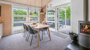 A modern dining area with a wooden table, chairs, and pendant lights. - "Noreen" - 1.4km to the fjord by Interhome (Hemmet)
