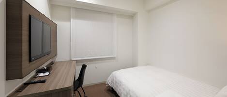 Una habitación de hotel con cama, escritorio con televisor, silla y ventana con persianas.