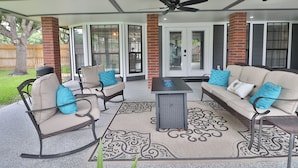 Eine Terrassengruppe mit einer Couch, Stühlen, einem Tisch und einem Deckenventilator.