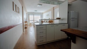 Eine moderne Küche mit weißen Schränken, einer Holz Arbeitsplatte und einem eingebauten Backofen.
