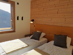Un dormitorio con dos camas, una ventana y un cabecero de madera.