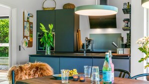 A modern kitchen with dark cabinetry, a central island, and a hanging light fixture. - "Melina" - 900m to the fjord by Interhome (Farsø)