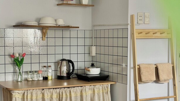 A kitchen with a wooden countertop, a kettle, a pot, and a shelf with dishes and a plant. - TRIP HOME 2 (Ho Chi Minh City)