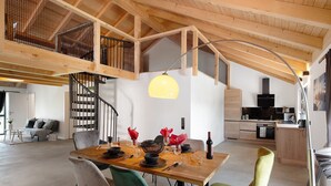A dining area with a wooden table, chairs, and a staircase leading to an upper level. - Holiday Apartment 'Ferienoase Im Land Der 1000 Seen' with Private Terrace, Shared Garden & Wi-Fi (Karstädt)