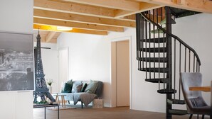 A modern interior with a spiral staircase, a sofa, and a model of the Eiffel Tower. - Holiday Apartment 'Ferienoase Im Land Der 1000 Seen' with Private Terrace, Shared Garden & Wi-Fi (Karstädt)