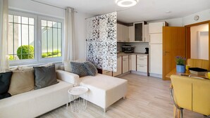 Uma sala moderna com sofá, uma mesinha e uma poltrona amarela.