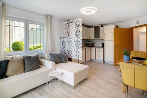 A modern living room with a sofa, a small table, and a yellow chair.