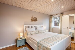 Une chambre à coucher avec un lit, une table de chevet et une fenêtre avec des rideaux.