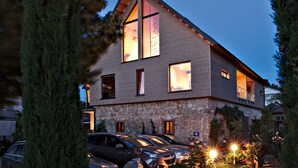 A two-story building with a stone base and a sloped roof. - Riesling Apartment with Shared Pool, Garden, and Wi-Fi (Auggen)