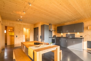 Une cuisine moderne avec des murs en bois, un ßlot central et des appareils électroménagers intégrés.