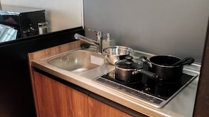 Une cuisine dotée d’un évier en acier inoxydable, d’une cuisinière encastrée et d’armoires en bois.