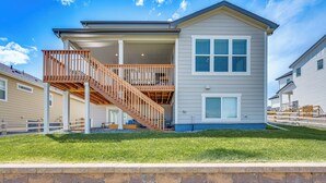 A two-story house with a wooden deck and a covered porch. - Berthoud Home w/ Fire Pit, Close to Lake Loveland! (Berthoud)