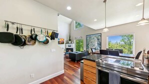 A modern kitchen with a stainless steel stove, wooden cabinets, and a hanging pot rack. - Forest Mtn Lodge: Hot Tub, Game Room, Near Trail (South Lake Tahoe)