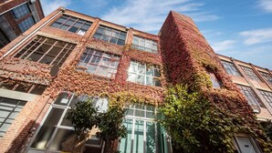 A building with a brick facade partially covered in red ivy. - Spacious Warehouse Conversion, 2 Bdrms & Parking (Footscray)