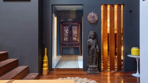 A modern interior with a wooden staircase, a statue, and a traditional cabinet. - Spacious Warehouse Conversion, 2 Bdrms & Parking (Footscray)